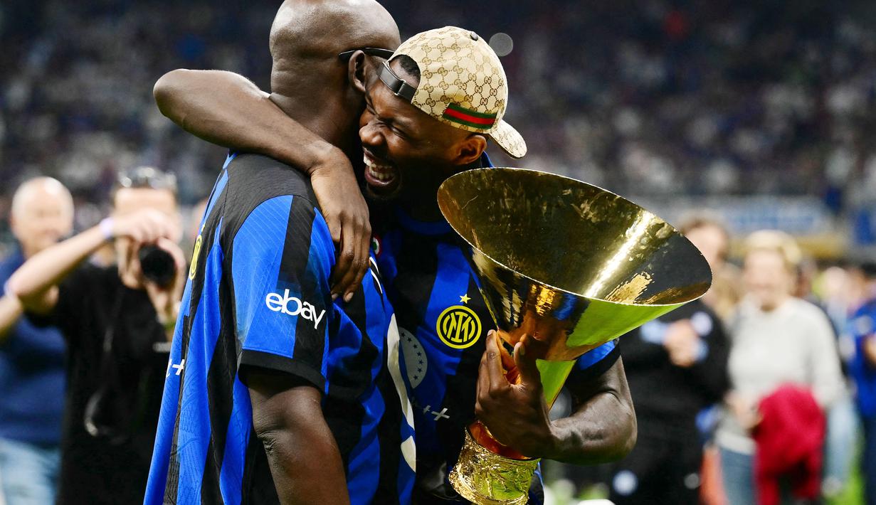 Pemain Inter Milan, Marcus Thuram, memeluk sang ayah yakni Lilian Thuram saat merayakan gelar juara Serie A di Stadion Giuseppe Meazza, (19/5/2024). Nerazzurri menjadi kampiun Liga Italia musim ini. (AFP/Marco Bertorello)