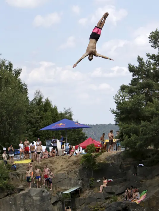 Aksi seorang peserta bergaya di udara saat kompetisi cliff diving di kawasan Bohemian, Republik Ceko, Jumat (31/7/2015). (REUTERS/David W Cerny)