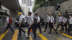 Para siswa sekolah mengenakan topeng dan helm berjalan di luar St. Paul's College selama protes di Hong Kong, Selasa (3/9/2019). Puluhan ribu siswa di Hong Kong mogok sekolah di hari pertama tahun ajaran baru. (AP Photo/Kin Cheung)