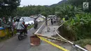 Kendaraan melintas dekat lokasi jalan longsor di Desa Bondawuna, Kabupaten Bone Bolango, Gorontalo, Selasa (30/4/2019). Hujan yang mengguyur wilayah Kabupaten Bone Bolango mengakibatkan empat desa di Kecamatan Suwawa Selatan, dan Bulango Timur Bone Bolango banjir. (Liputan6.com/Arfandi Ibrahim)