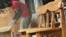 Pekerja menghaluskan furnitur atau perlengkapan rumah berbahan kayu dari Jepara di Ciputat, Tangerang Selatan, Selasa (14/9/2021). Pedagang di tempat tersebut mengakui selama PPKM ini daya beli masyarakat terhadap furnitur meningkat. (Liputan6.com/Johan Tallo)