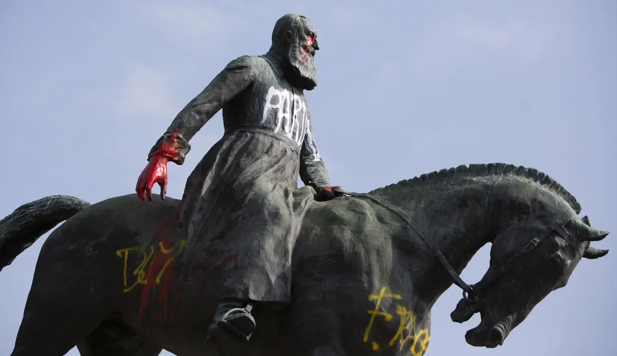 Patung Raja Belgia Leopold II dicoret dengan cat dan grafiti di Brussel, Belgia, Rabu (10/6/2020). Di tengah protes dunia atas kematian George Floyd, patung Raja Leopold II dirusak karena pemerintahannya yang brutal ketika menguasai Kongo ratusan tahun silam. (AP Photo/Virginia Mayo)