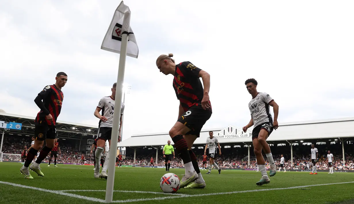 Pemain Manchester City, Erling Haaland (tengah), berusaha mengontrol bola dalam pertandingan pekan ke-34 Premier League 2022/2023 melawan Fulham yang berlangsung di Craven Cottage, Minggu (30/4/2023). Gol cepat Haaland ke gawang Fulham membuat dirinya mengkoleksi gol ke-50 sepanjang musim ini di lintas kompetisi. (AFP/Adrian Dennis)