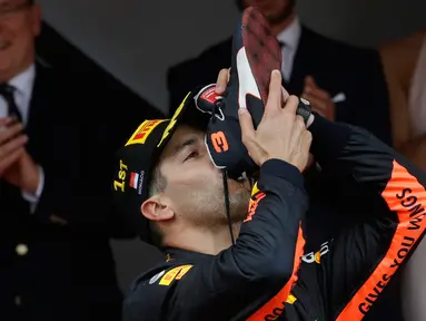 Pembalap Red Bull Daniel Ricciardo meminum sampanye dari sepatu saat merayakan kemenangannya di balapan Grand Prix Monaco Formula 1, Monaco (27/5). (AP/Luca Bruno)