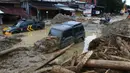 Mobil-mobil terjebak lumpur di daerah yang terkena banjir bandang di Masamba, Sulawesi Selatan, Rabu (15/7/2020). Banjir bandang akibat tingginya curah hujan tersebut mengakibatkan 16 orang meninggal dunia dan puluhan warga dilaporkan masih dalam pencarian. (AP/Khaizuran Muchtamir)