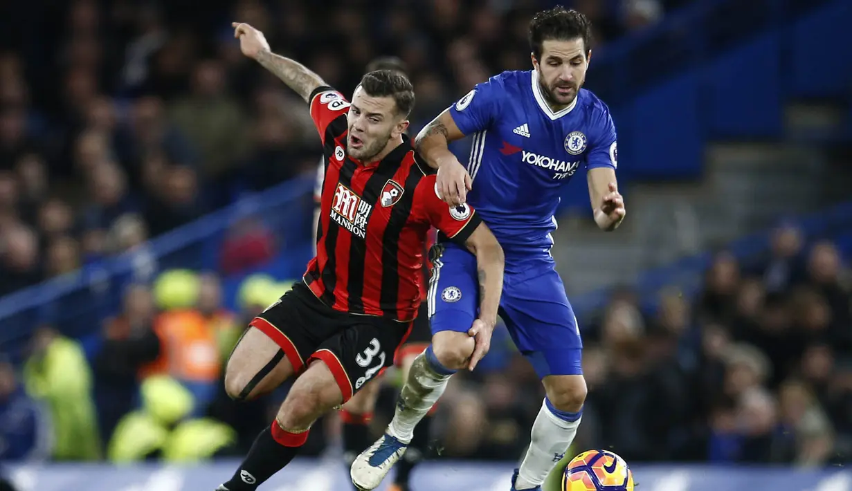 Gelandang Chelsea, Cesc Fabregas, menahan laju gelandang Bournemouth, Jack Wilshere. Pada laga ini Chelsea kembali turun dengan formasi andalannya 3-4-3, sementara Bournemouth menggunakan skema 3-5-1-1. (Reuters/Peter Nicholls)