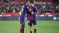 Pemain depan Barcelona asal Brasil #11, Raphinha, berbicara dengan gelandang Barcelona asal Spanyol #08, Pedri (Kanan), selama pertandingan liga Spanyol antara Sevilla FC dan FC Barcelona di Stadion Ramon Sanchez Pizjuan di Seville, Senin dini hari WIB (9-2-2025). (CRISTINA QUICLER/AFP)