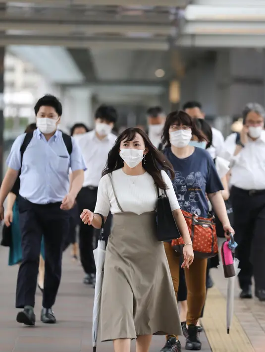 Orang-orang yang mengenakan masker berjalan di Minato-ku, Tokyo, Jepang (30/6/2020). Pemerintah kota metropolitan Tokyo mengonfirmasi kasus infeksi baru COVID-19 yang telah mencapai angka 50 di tengah kekhawatiran kemunculan kembali kasus penularan. (Xinhua/Du Xiaoyi)