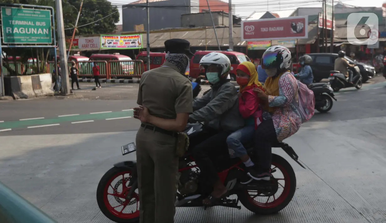 Petugas Satpol PP memberitahu warga terkait penutupan kawasan Kebun Binatang Ragunan, Jakarta, Minggu (16/5/2021). Sejumlah kawasan wisata di DKI Jakarta ditutup sementara untuk umum hingga 18 Mei 2021 untuk pemberlakukan penguatan protokol kesehatan COVID-19. (Liputan6.com/Helmi Fithriansyah)