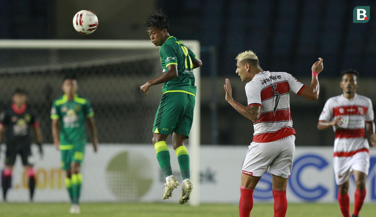 Striker Persebaya Surabaya, Mochammad Supriadi (kiri) menyundul bola di depan bek Madura United, Jaimerson Xavier dalam laga matchday ke-2 Grup C Piala Menpora 2021 di Stadion Si Jalak Harupat, Bandung, Minggu (28/3/2021). (Bola.com/M Iqbal Ichsan)