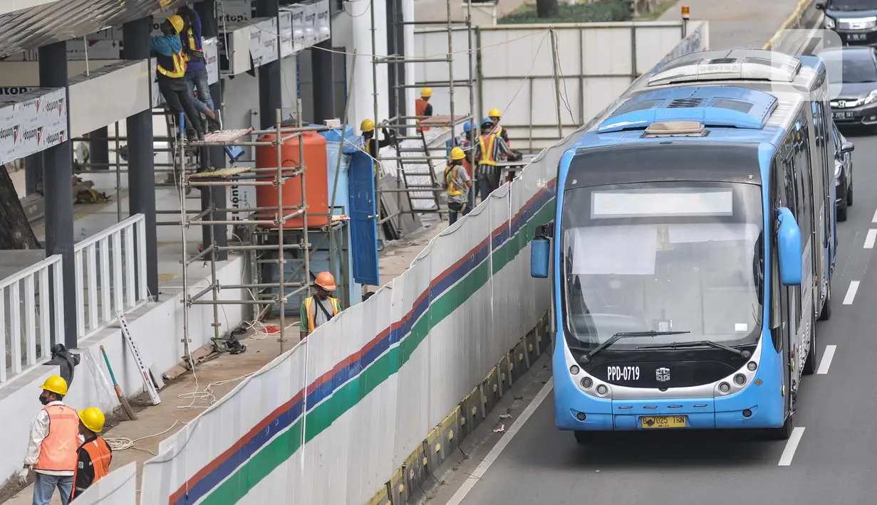 Bus Transjakarta melintas di samping proyek revitalisasi halte TransJakarta Gelora Bung Karno (GBK), Jakarta Pusat, Senin (25/7/2022). PT TransJakarta terus mengebut proyek konstruksi revitalisasi sembilan halte yang akan berlangsung sekitar enam bulan dan akan difungsikan kembali secara bertahap sampai dengan dirampungkan secara keseluruhan pada Desember 2022. (merdeka.com/Iqbal S Nugroho)