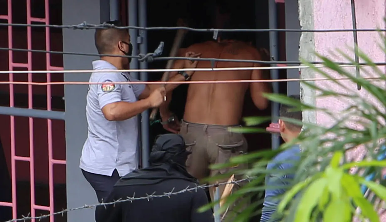 Petugas sipir mengamankan salah satu narapidana setelah puluhan napi menggelar aksi protes di atap penjara menuntut penggantian kepala penjara di Manila City Jail, Filipina (13/10). REUTERS/Stringer)