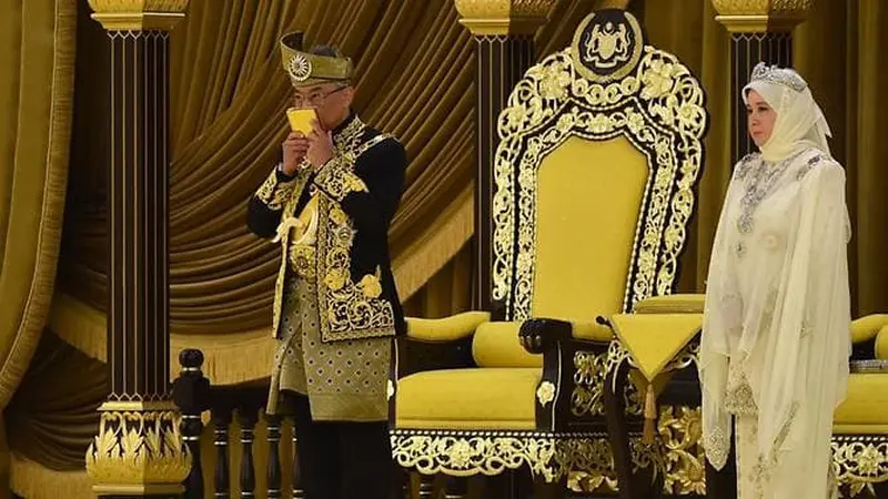 Raja Malaysia Sultan Abdullah Ri'ayatuddin Al-Mustafa Billah Shah mencium salinan Alquran di samping Raja.(AFP/Malaysia's Department of Information/Najib Mohaini)
