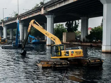 Eskavator amphibi dioperasikan untuk mengeruk lumpur yang mengendap di Kali Ancol, Jakarta, Rabu (11/1). (Liputan6.com/Gempur M Surya)