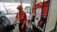 Turunnya harga bahan bakan minyak (BBM) jenis premium membuat kendaraan roda empat ikut mengisinya,  Jakarta, Kamis (1/1/2015). (Liputan6.com/Miftahul Hayat)