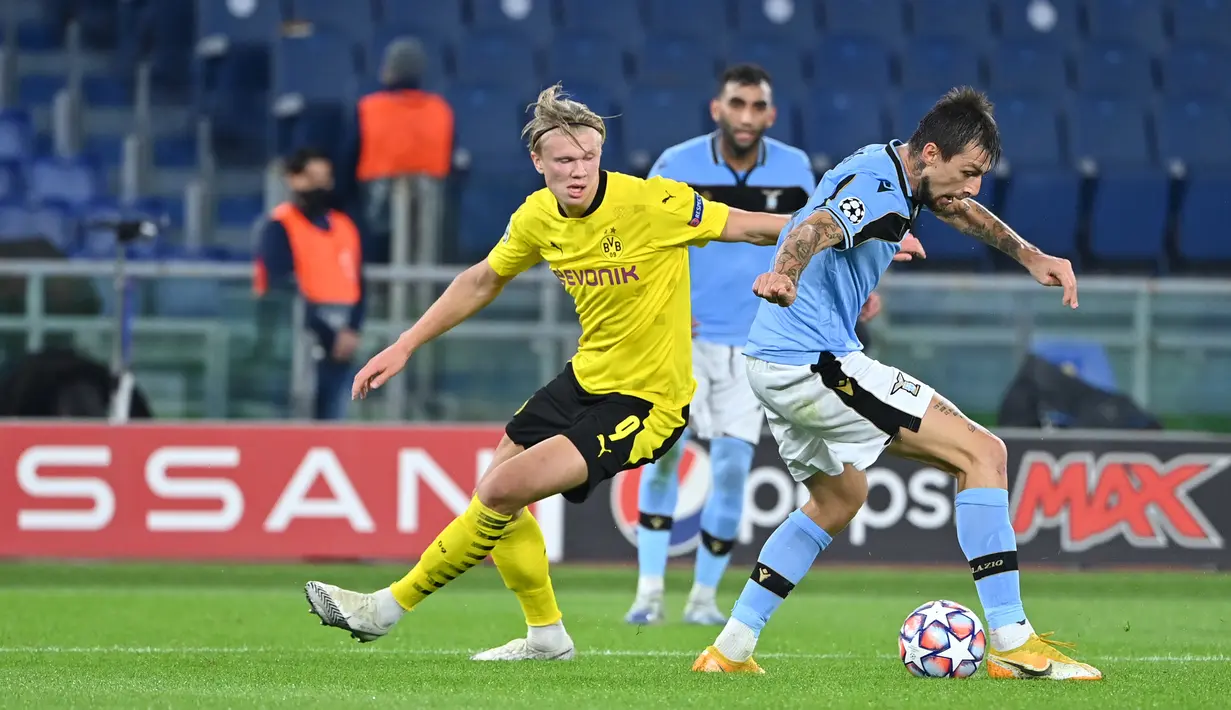 Penyerang Borussia Dortmund, Erling Braut Haland (kiri) berebut bola dengan bek Lazio, Francesco Acerbi pada pertandingan perdana Grup F Liga Champions 2020 di Stadion Olimpico, Rabu (21/10/2020) dini hari WIB. Lazio menang 3-1 atas Borussia Dortmund. (Alberto PIZZOLI/AFP)