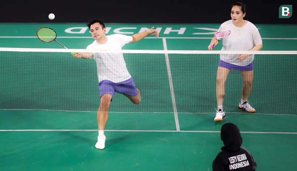 Pasangan selebritas Raffi Ahmad dan Nagita Slavina berusaha mengembalikan kok saat bertanding melawan pasangan Rizky Billar dan Lesti Kejora pada laga bulu tangkis ganda campuran Turnamen Olahraga Selebriti Indonesia (TOSI) di GOR UNJ, Jakarta, Minggu (16/07/2023). Raffi dan Gigi kalah dua set langsung dari Rizky Billar dan Lesti dengan skor 12-21, 10-21.(Bola.com/Bagaskara Lazuardi)