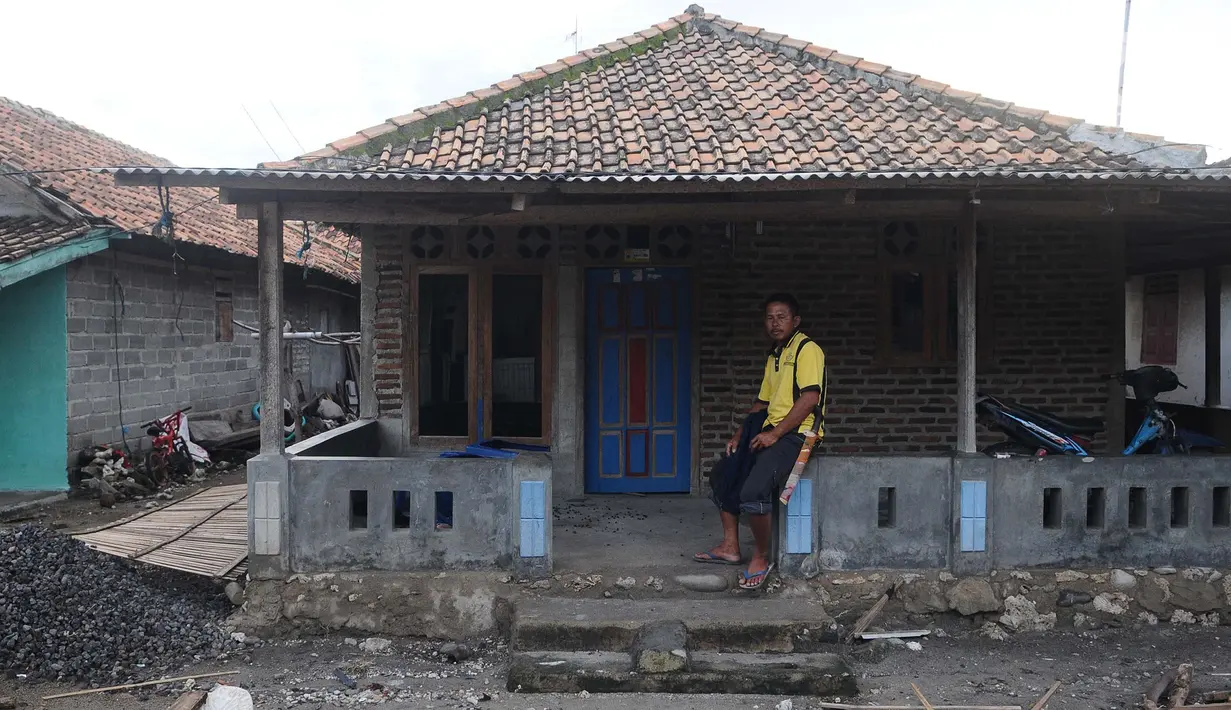 Seorang pria duduk di depan rumahnya di dusun Regahan Lada, Pulau Sebesi, Lampung, Senin (31/12). Banyak warga dusun ini yang bertahan dan enggan meninggalkan rumahnya pascatsunami Selat Sunda pada 22 Desember lalu. (Liputan6.com/Herman Zakharia)