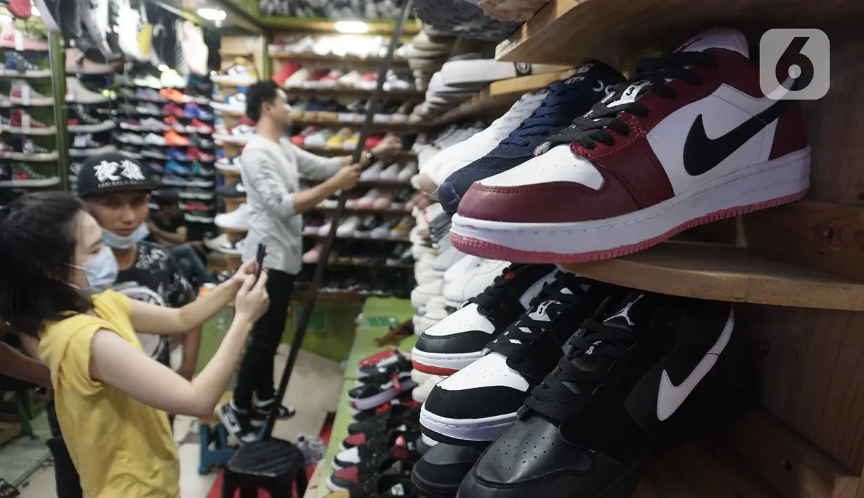 Pedagang sepatu melayani pembeli di Taman Puring, Jakarta,Rabu (21/10/2020). Menurut pedagang penjualan sepatu di lokasi tersebut menurun hingga sebesar 60% akibat sepinya pengunjung di masa pandemi. (Liputan6.com/Angga Yuniar)