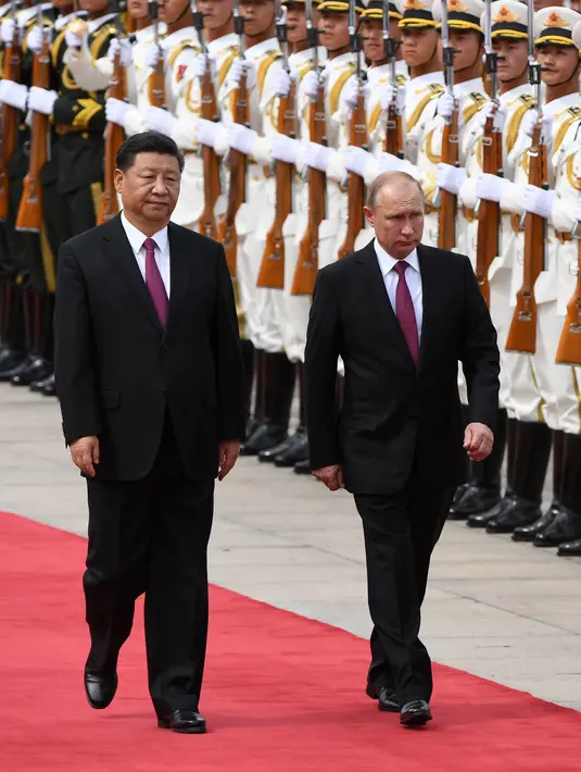 Presiden Rusia Vladimir Putin didampingi Presiden China Xi berjalan bersama saat upacara penyambutan di Aula Besar Rakyat di Beijing, China (8/6). Xi menambahkan, kedua negara juga saling mendukung kepentingan masing-masing. (AFP/Pool/ Greg Baker)