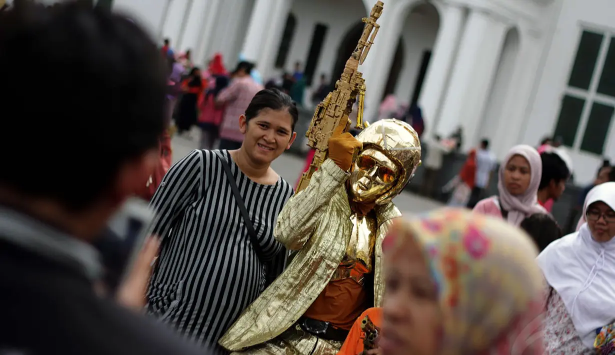 Kawasan Kota Tua Jakarta masih menjadi lokasi wisata favorit warga Jakarta, Jumat (26/12/2014). Salah satu pengunjung berfoto bersama manusia patung di kawasan Kota Tua Jakarta. (Liputan6.com/Faizal Fanani)