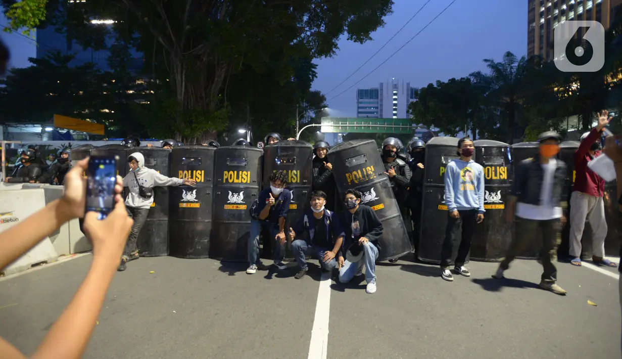 Pendemo foto bersama anggota kepolisian saat aksi menolak Omnibus Lawa UU Cipta Kerja di kawasan Patung Kuda, Jakarta, Selasa (20/10/2020).  Anggota Marinir membubarkan dan mengawal pulang massa pendemo  ke rumah masing-masing. (merdeka.com/Imam Buhori)