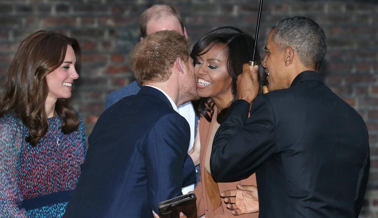 Pangeran Harry saat mencium pipi Michelle Obama saat Presiden AS Barack Obama berkunjung ke Kensington Palace, London , Inggris (22/4). Mereka akan mengadakan acara makan malam. (REUTERS / Kevin Lamarque)