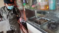 Petugas Satpol PP Kota Malang di depan sebuah warung makan yang menyediakan olahan daging anjing. Pengelola warung diminta tak lagi menjual daging non pangan itu setelah terbitnya SE Wali Kota Malang pada Senin, 17 Januari 2022