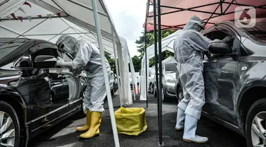 Petugas kesehatan melakukan tes usap PCR drive thru kepada pengguna kendaraan di halaman Rumah Sakit Pertamina Jakarta (RSPJ), Rabu (6/1/2021). RSPJ menyediakan layanan tes usap PCR mandiri secara drive thru guna melacak sekaligus memutus penyebaran Covid-19. (merdeka.com/Iqbal Nugroho)