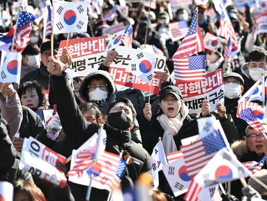 Para pendukung Presiden Korea Selatan yang dimakzulkan, Yoon Suk Yeol, melambaikan bendera Amerika Serikat dan Korea Selatan saat mereka berkumpul di dekat kediaman kepresidenan di Seoul pada tanggal 31 Desember 2024. (JUNG YEON-JE/AFP)