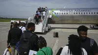 Para penumpang menunggu untuk menaiki pesawat World Atlantic di Bandara Internasional Toussaint Louverture di Port-au-Prince, Haiti, Senin, 20 Mei 2024. (AP Photo/Ramon Espinosa)