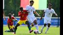 Bek Timnas Indonesia U-23, Komang Teguh (tengah) berebut bola dengan gelandang Guinea U-23, Issiaga Camara pada laga play-off antar-konfederasi menuju Olimpiade Paris 2024 di Stade Pierre Pibarot, Centre National du Football de Clairefontaine, Prancis, Kamis (9/5/2024). (AFP/Miguel Medina)