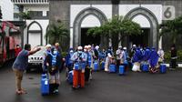 Seorang pria mengarahkan jemaah umrah menuju bus untuk diberangkatkan usai masa karantina di Asrama Haji Pondok Gede, Jakarta, Selasa (11/1/2022). Sebanyak 436 calon jemaah umrah diberangkatkan setelah sebelumnya pemerintah memberangkatkan 419 jemaah seluruh Indonesia.  (merdeka.com/Imam Buhori)