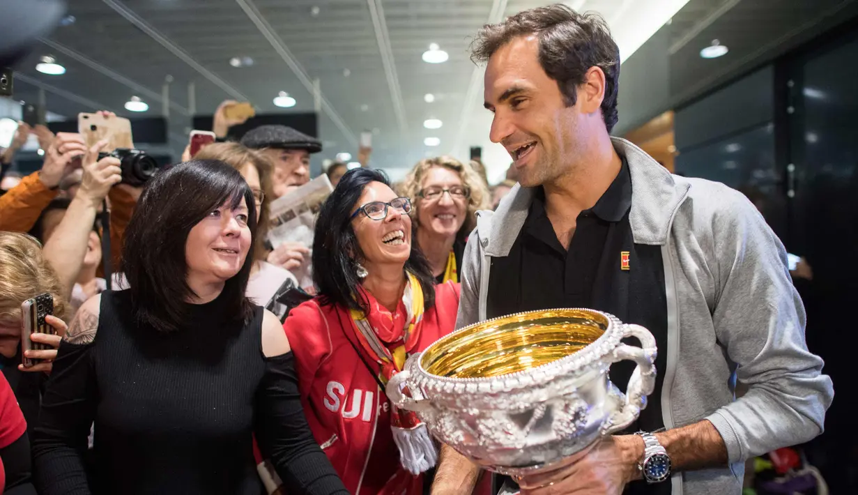 Petenis Swiss Roger Federer menyapa penggemarnya saat tiba di Bandara Zurich, di Kloten, Swiss, (30/1). Federer mengalahkan petenis Kroasia Marin Cilic 6-2, 6-7(5), 6-3, 3-6, 6-1. (Ennio Leanza/Keystone via AP)