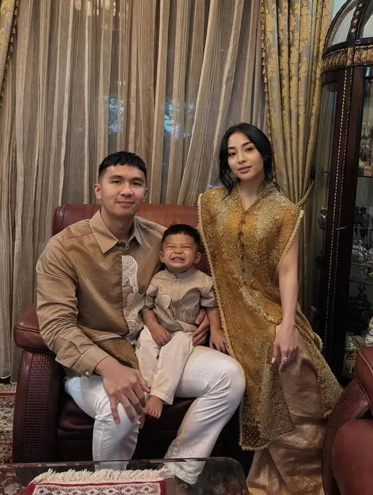 Penampilan kompak keluarga kecil Nikita Willy mengenakan outfit bernuansa senada. Nikita Willy tampil anggun elegan mengenakan atasan lace bernuansa keemasan, sedangkan sang suami dan anak memilih outfit berwarna cokelat yang serasi. [Foto: Instagram/saptodjojokartiko]