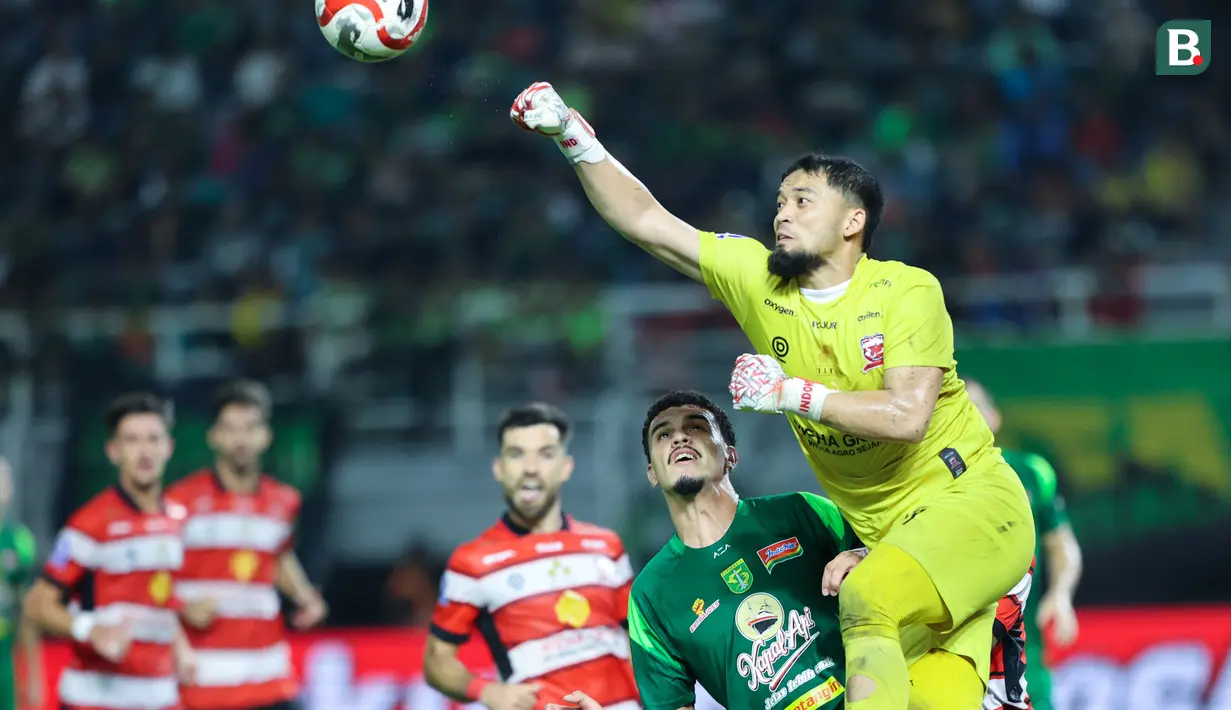 Kiper Madura United, Diky Indriyana, berusaha menghalau bola saat melawan Persebaya Surabaya pada laga BRI Super League di Stadion Gelora Bung Tomo, Surabaya, Jumat (17/04/2026). (Bola.com/M Iqbal Ichsan)