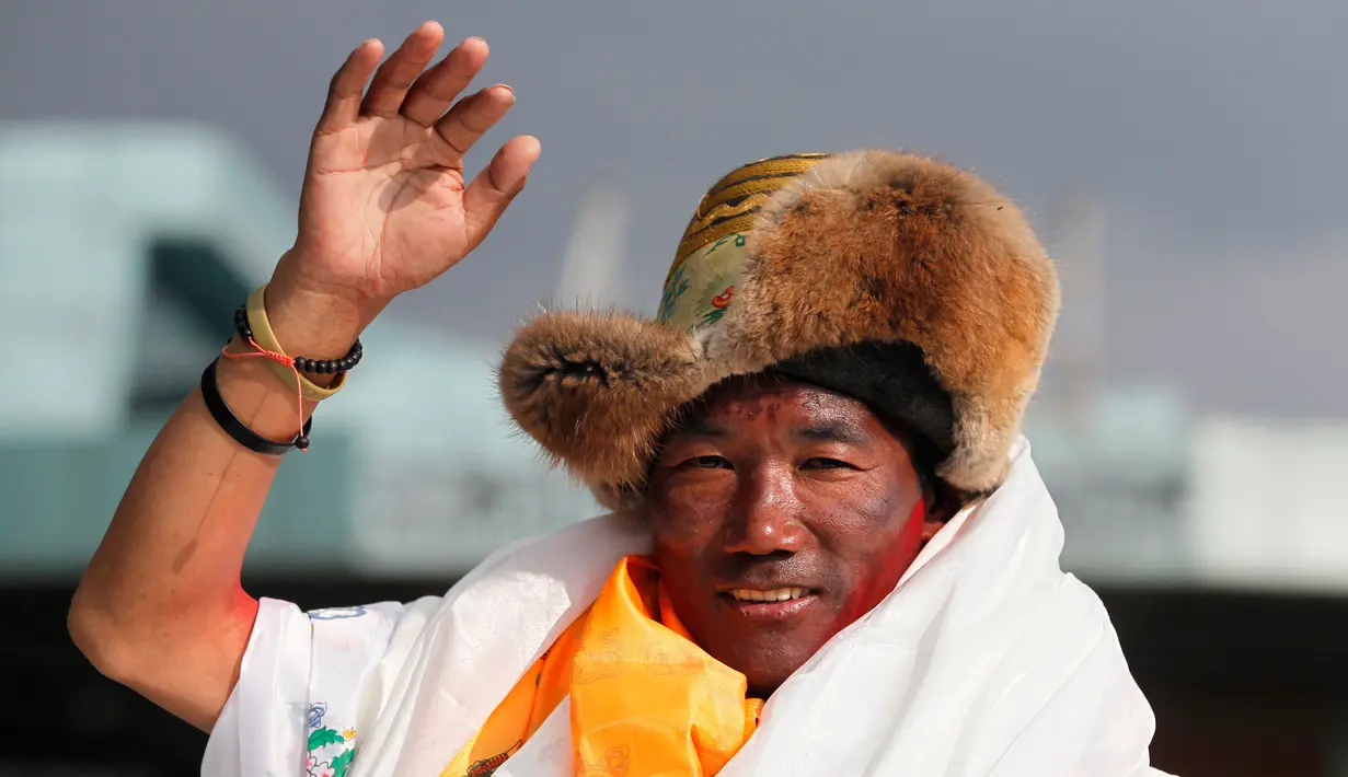 Seorang pemandu profesional, Kami Rita (48) melambaikan tangan setibanya di Kathmandu, Nepal, 20 Mei 2018. Kami Rita mencatatkan rekor dunia menjadi orang yang paling banyak mencapai puncak gunung Everest setinggi 8.848 meter. (AP/Niranjan Shrestha)