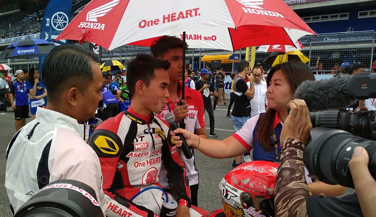 Pebalap Astra Honda Racing Team, Gerry Salim, melakukan wawancara usai ARRC 2017 di Sirkuit Buriram, Thailand, Sabtu (2/12/2017). Gerry Salim menjadi rider Indonesia pertama yang menjuarai ARRC kelas Asia Production 250. (Bola.com/Muhammad Wirawan)