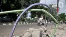 Kendaraan melintasi kabel proyek PLN yang terbengkalai di Jalan Jatinegara Kaum, Jakarta, Minggu (12/1/2020). Kurangnya pengawasan dalam penyelesaian proyek instalasi listrik bawah tanah PLN tersebut menyebabkan banyak kabel masih muncul di trotoar dan bahu jalan. (merdeka.com/Iqbal S. Nugroho)