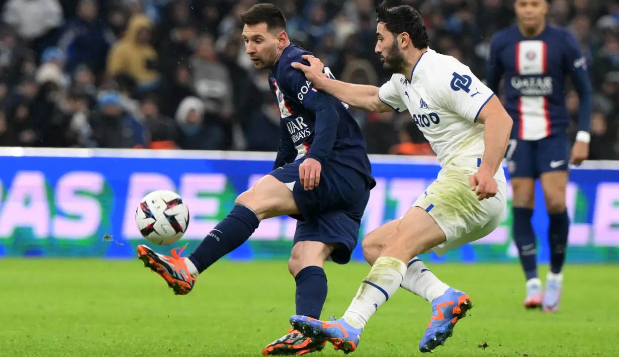 Penyerang Paris Saint-Germain (PSG) Lionel Messi berebut bola dengan bek Marseille Sead Kolasinac dalam laga pekan ke-25 Liga Prancis 2022-2023, di Stadion Velodrome pada Senin (27/2/2023) dini hari WIB. PSG unggul delapan angka atas Marseille yang membayangi di peringkat kedua. (Photo by NICOLAS TUCAT / AFP)