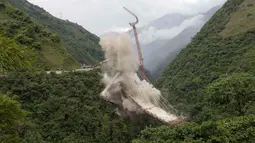 Peruntuhan sebuah jembatan gantung oleh para insinyur di Chirajara, Kolombia, Rabu (11/7). Sebelumnya, sebagian jembatan runtuh dan menewaskan sembilan pekerja saat pembangunannya pada Januari lalu. (AP Photo/Fernando Vergara)