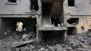 Serangan udara Israel menyasar sejumlah wilayah di Lebanon, terutama selatan dan pinggiran Kota Beirut. Tampak dalam foto, seorang wanita menaiki tangga di sebuah bangunan yang hancur akibat serangan udara Israel di kota pelabuhan Tyre, Lebanon selatan, Kamis, 26 Maret 2026. (AP Photo/Hussein Malla)