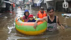 Petugas mengevakuasi anak-anak korban banjir menggunakan perahu karet di kawasan Karet Pasar Baru Barat, Jakarta, Selasa (25/2/2020). Banjir yang terjadi sejak subuh akibat luapan Kanal Banjir Barat tersebut merendam ratusan rumah hingga setinggi dua meter. (merdeka.com/Arie Basuki)