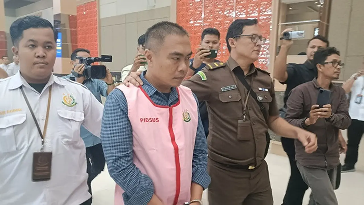 Tersangka pengemplang pajak digiring oleh petugas Kejati Riau ke mobil tahanan untuk dibawa ke penjara.