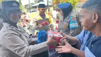 Polisi wanita membagikan nasi kotak dalam program Jumat Berkah Polres Rokan Hulu. (Liputan6.com/M Syukur)