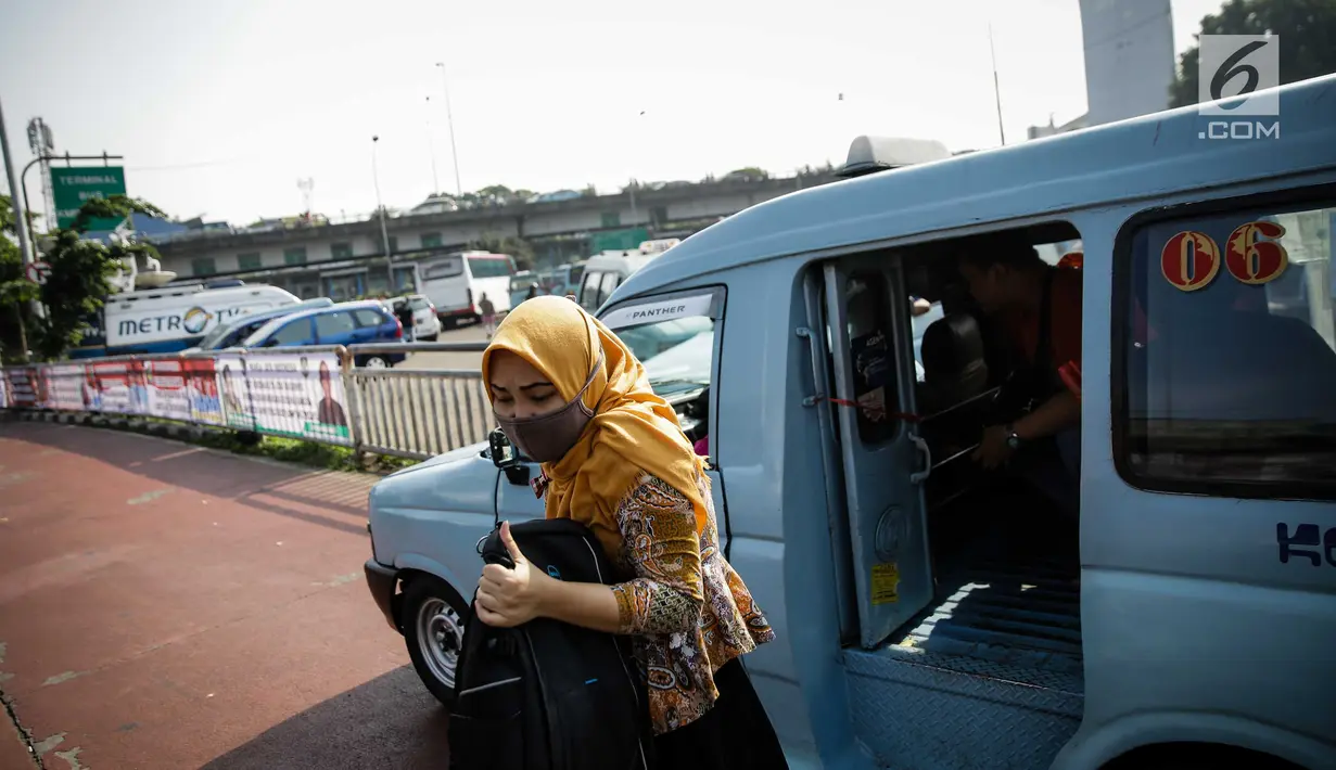 Penumpang turun dari angkutan umum (angkot) di Terminal Kampung Melayu, Jakarta, Jumat (26/5). Setelah sempat berhenti beroperasi pasca-ledakan bom Rabu (24/5) lalu, Terminal Kampung Melayu kembali dibuka dan dioperasikan. (Liputan6.com/Faizal Fanani)