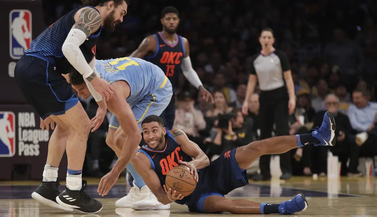 Pemain Oklahoma City Thunder, Josh Huestis jatuh saat berebut bola dengan pemain Los Angeles Lakers, Brook Lopez pada laga NBA basketball game di Staples Center, Los Angeles, (3/1/2018). Lakers kalah 96-133. (AP/Jae C. Hong)