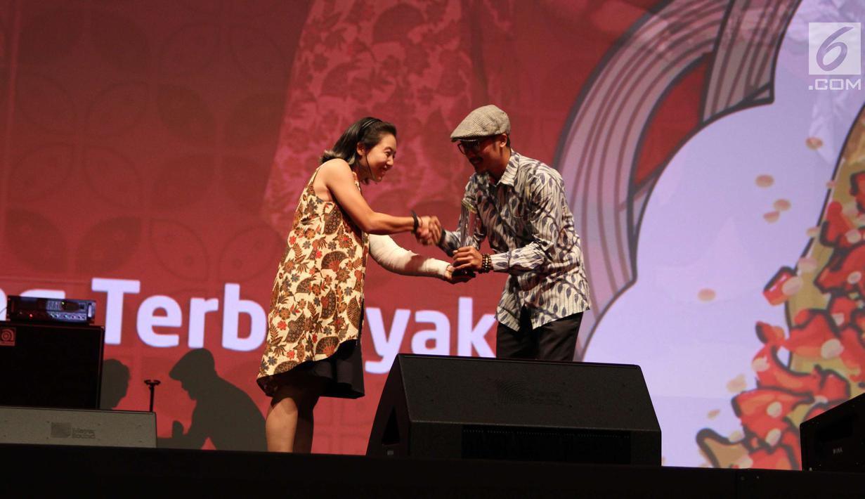 Product Manager Go-Jek Yeti Kim memberi penghargaan pada pemilik Pisang Goreng Madu Ibu Nanik dalam acara Malam Juara Go-Food 2018 di Jakarta, Jumat (23/2). Go-Jek mengapresiasi kuliner UMKM yang telah tumbuh bersama Go-Food. (Liputan6.com/Angga Yuniar)
