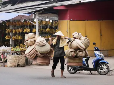Pedagang menggedong daganganya untuk di jaual berkeliling di Tangerang, Banten, Kamis (2/9/2021). Menteri Koperasi dan UKM Teten Masduki menyampaikan realisasi penyaluran BPUM 2021 sudah mencapai Rp14,21 triliun atau 92,35 persen dari total Rp15,36 triliun. (Liputan6.com/Angga Yuniar)