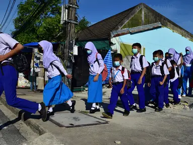 Para siswa tiba di Sekolah Pimarnvit, Provinsi Narathiwat, Thailand, 20 Mei 2022. Thailand melanjutkan sekolah tatap muka secara nasional untuk tahun ajaran baru setelah bertahun-tahun terganggu karena pandemi COVID-19. (Madaree TOHLALA/AFP)